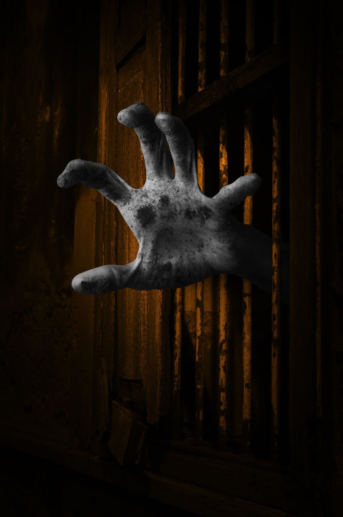 Zombie hand rising out from the old window ancient house, Halloween concept